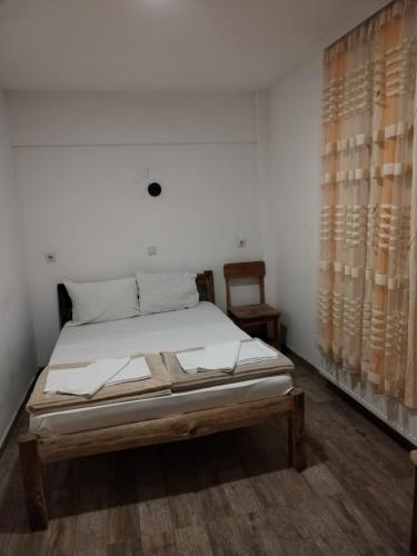 a bedroom with a bed and a chair and curtains at Etno selo Srna in Kalna