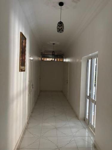an empty room with a hallway with a ceiling at Cosy Baobab in Warang