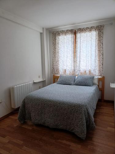 a bedroom with a bed in front of a window at PASEO DE LOS AYERBE Nº5 in Canfranc-Estación