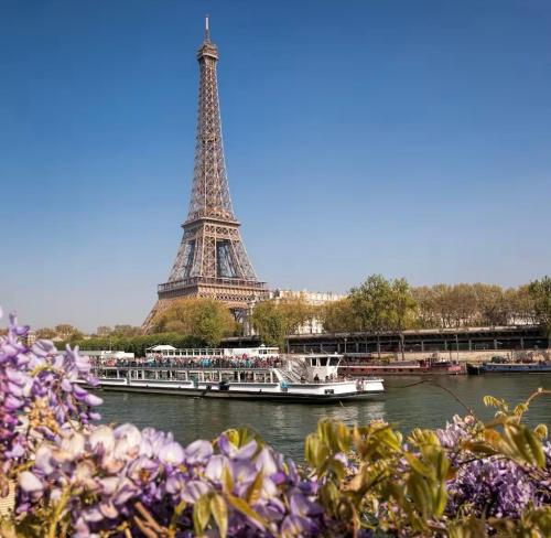 蒙泰夫兰Suite Oceïna Proche Disneyland Parking 4 Pers的埃菲尔铁塔前河里的一艘船