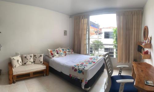 a bedroom with a bed and a chair and a window at Apartamento grande in Garzón