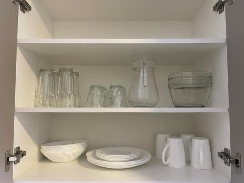 a shelf with bowls and glass jars and plates at Apartamento Centrico con parqueo gratuito in Estación Pamplona