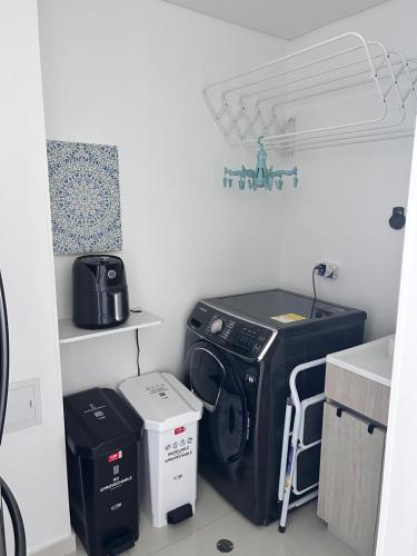 a kitchen with a washing machine and boxes in a room at Apartamento espectacular Santa Marta in Santa Ana