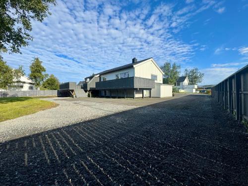 a house on a road with a fence at Lofoten-City Center-New apartment-Near the airport in Leknes