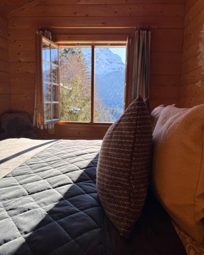 a bedroom with a bed and a window with a view at Chalet Toccata, cosy et lumineux in Les Diablerets