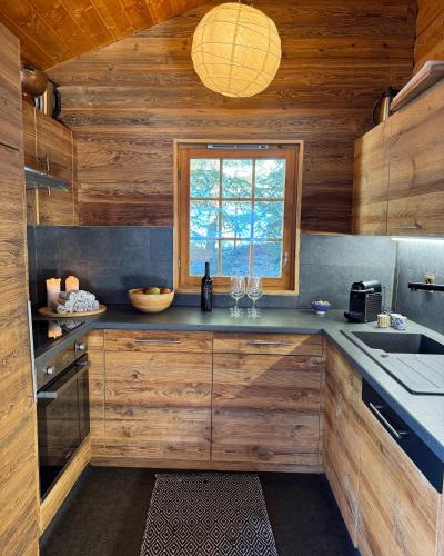 a kitchen with wooden walls and a window and a counter at Chalet Toccata, cosy et lumineux in Les Diablerets