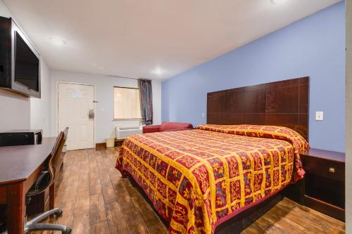 a hotel room with a bed and a television at Hotel O Luxury Inn Channelview Baytown I-10 in Channelview