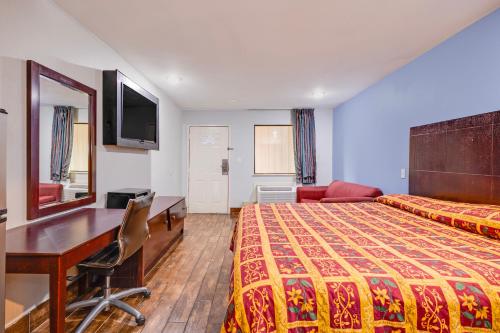 a hotel room with a bed and a desk at Hotel O Luxury Inn Channelview Baytown I-10 in Channelview