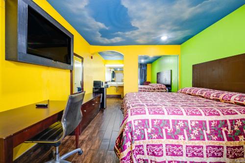a hotel room with a bed and a desk and a tv at Hotel O Luxury Inn Channelview Baytown I-10 in Channelview