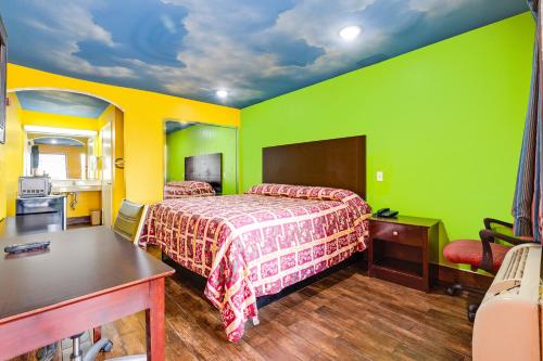 a bedroom with green and yellow walls and a bed at Hotel O Luxury Inn Channelview Baytown I-10 in Channelview