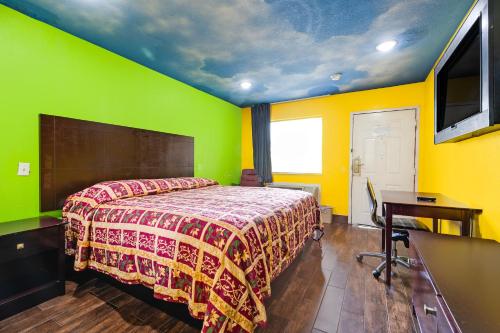 a bedroom with a bed with green and yellow walls at Hotel O Luxury Inn Channelview Baytown I-10 in Channelview