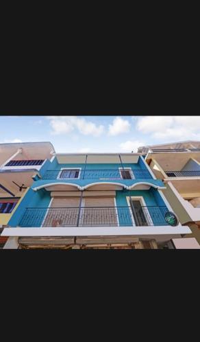 a tall blue building with a balcony at Om Ganesh Guest House1 in Arambol