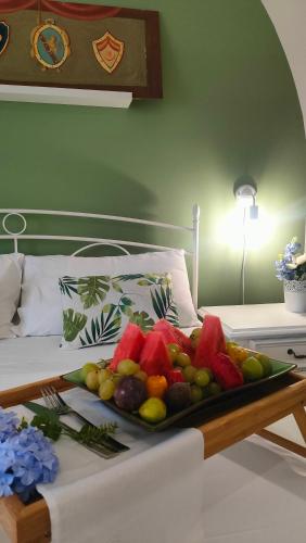 ein Tablett mit Obst auf dem Bett in der Unterkunft Villa Triscele Holiday Home in Partinico