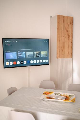 a room with a table and a tv on the wall at Casa Sole - Villetta al mare, patio e relax in Carrao