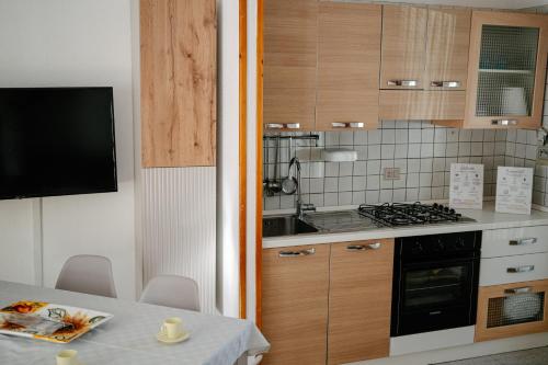 a kitchen with a table and a stove top oven at Casa Sole - Villetta al mare, patio e relax in Carrao