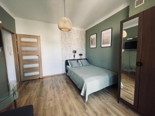 a bedroom with a bed and a mirror at ComeWa Apartments in Warsaw