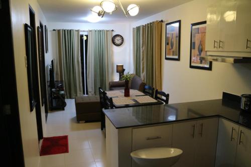 a kitchen with a counter top and a living room at The Courtyards Goshen in Baguio