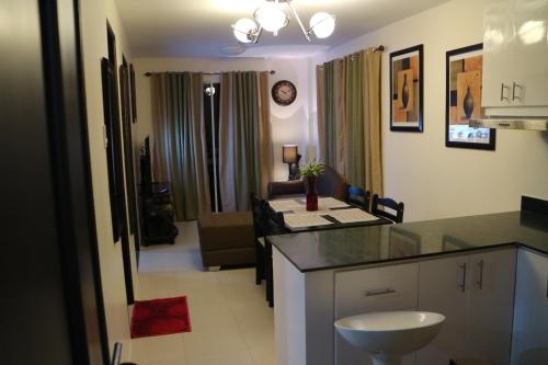 a kitchen with a counter top and a living room at The Courtyards Goshen in Baguio