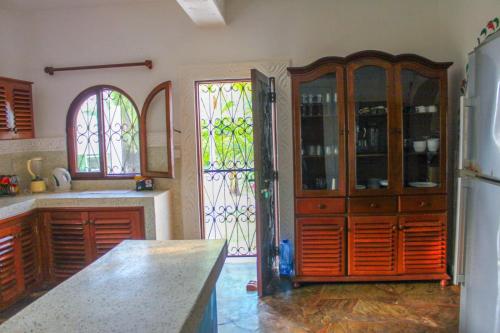 a kitchen with wooden cabinets and stained glass windows at Sal & Lala villa watamu in Watamu