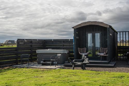 a small shed with two chairs and a table at Hot Tub Haven Farr North 2 in Wick
