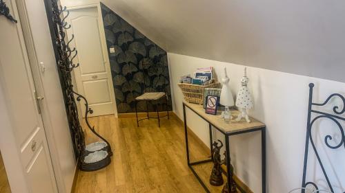 a hallway with a table and a chair in a room at Les Chambres d'hôtes du Faubourg in Saint-Riquier
