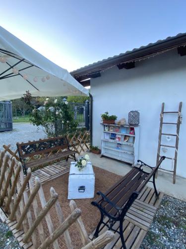 a group of benches with a table and an umbrella at La Cà di Carol in Tollegno
