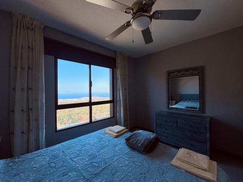 a bedroom with a bed with a window and a ceiling fan at Casa Colina Tenerife in San Isidro