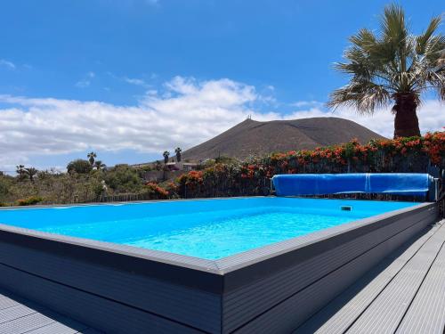a swimming pool with a table and a palm tree at Casa Colina Tenerife in San Isidro