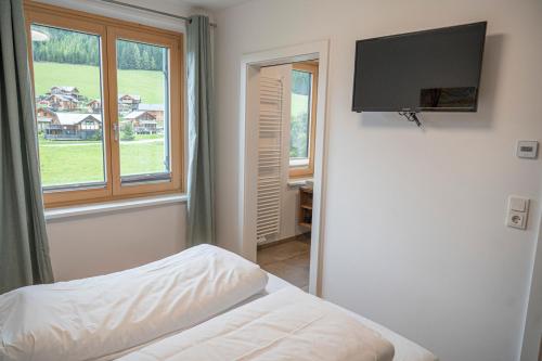 a bedroom with a bed and a flat screen tv at Triebenstein Hideaway in Hohentauern
