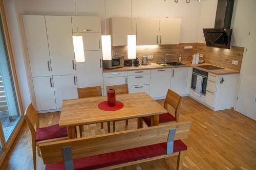 a kitchen with a wooden table and chairs and a kitchen with white cabinets at Triebenstein Hideaway in Hohentauern