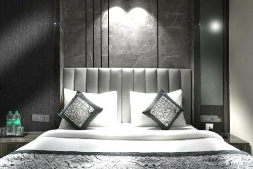 a bedroom with a large bed with white sheets and pillows at Hotel Mountain Bliss' New Delhi City center in New Delhi