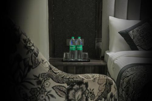 two bottles of water sitting on a table next to a chair at Hotel Mountain Bliss' New Delhi City center in New Delhi