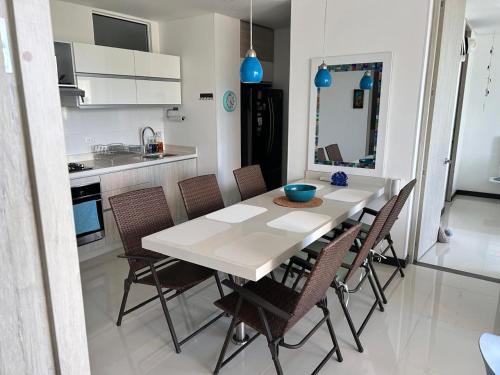 a kitchen and dining room with a white table and chairs at Apartamento espectacular Santa Marta in Santa Ana