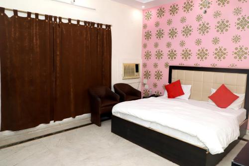 a bedroom with a bed with red pillows on it at Amrit resort in Alwar