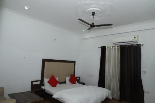 a bedroom with two beds and a ceiling fan at Amrit resort in Alwar