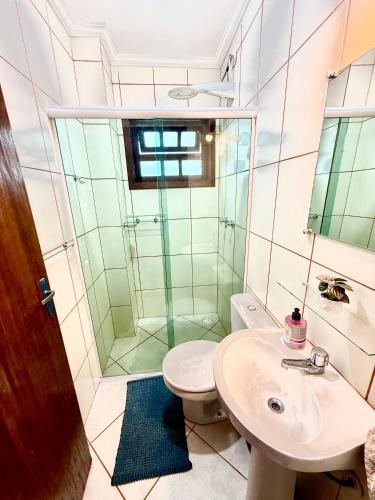 a bathroom with a toilet and a shower and a sink at Apartamento Ilha Comprida à beira-mar térreo in Ilha Comprida