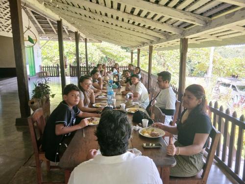a group of people sitting at a table eating food at Eco lodge finca magdalena in Altagracia