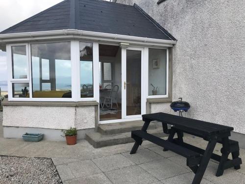 a picnic table in front of a house at Breathtaking view in Carrigart