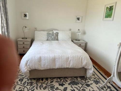 a bedroom with a white bed with two night stands at Breathtaking view in Carrigart