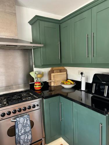a kitchen with green cabinets and a stove at Breathtaking view in Carrigart
