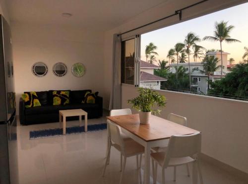 a living room with a table and a couch at punta cana residencial bavaro beach in La Cruz de Mendoza