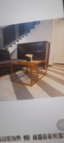 a wooden table with a vase of flowers on it at Ena Pa Hotel in Koforidua
