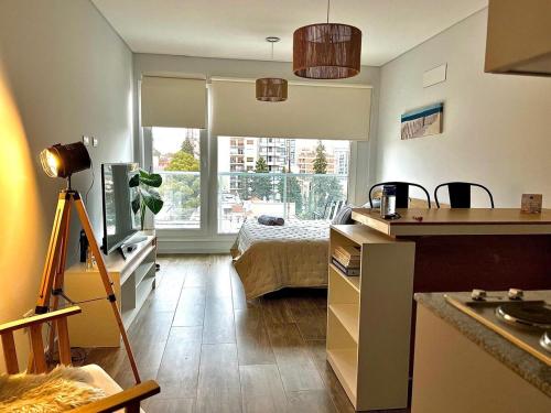 a room with a bedroom with a bed and a window at Premium Studio in Downtown in Neuquén