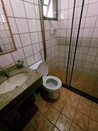 a bathroom with a toilet and a sink at Aparthotel Praia do Pero in Cabo Frio