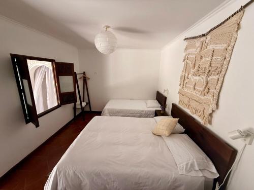 a bedroom with two beds and a window at Casa del Sol Antigua in Antigua Guatemala