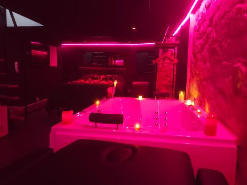 a room with a hot tub with candles in it at La Cachette Secrete - Love Room à Caen en Normandie avec Balnéo et Sauna Privatif in Caen