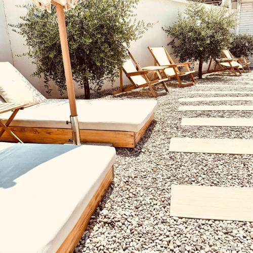 a patio with chaise lounge chairs and an umbrella at City Apartment One in Mostar