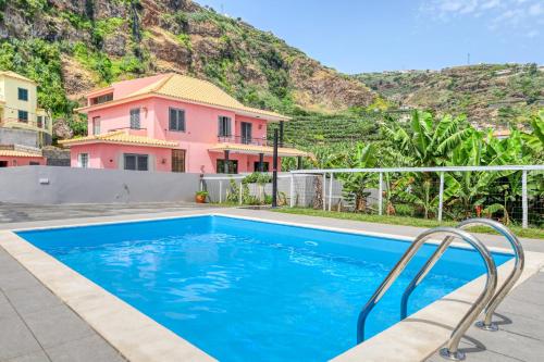 a house with a swimming pool in front of a mountain at Casa da Tia Celeste III, a Home in Madeira in Ponta do Sol