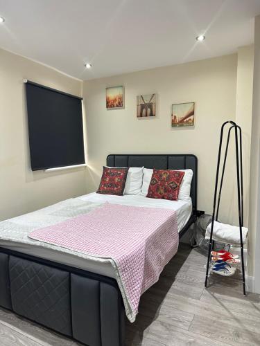 a bedroom with a large bed with a pink blanket at Room 3 - En-suite for 2 people in London
