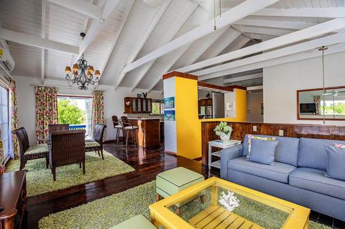 a living room with a blue couch and a table at Hideaway Villa 2 Minute walk to Gracebay beach in The Bight Settlements